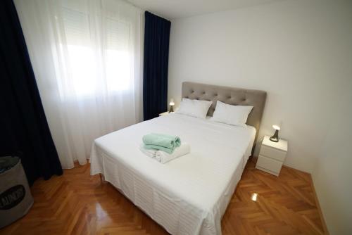 扎达尔Simon's apartment的卧室配有白色的床和2条毛巾