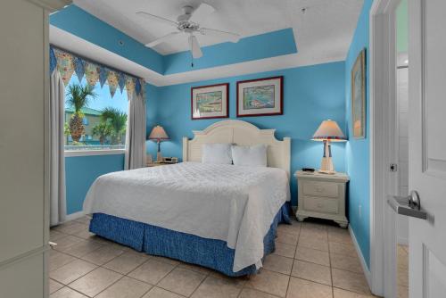沃尔顿堡滩Destin West Gulfside #203的一间卧室设有一张床和蓝色的墙壁