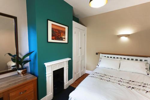 温彻斯特Boscobel Apartments Up的卧室配有白色的床和绿色的墙壁