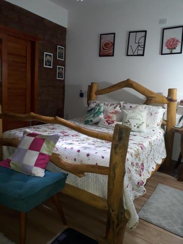 SêrroCasa dos Sonhos Hospedaria的一间卧室配有一张木床和一把椅子
