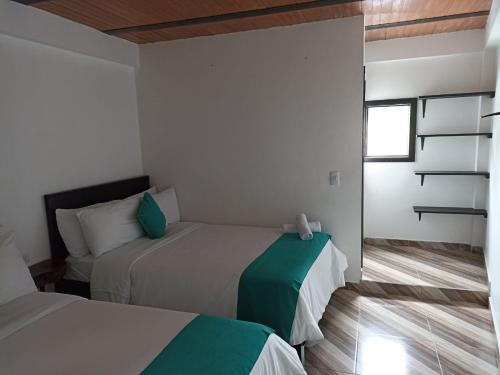 圣奥古斯丁Hotel SAMAI的一间卧室设有两张床和窗户。