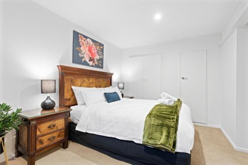 皇后镇Alpine Home with Amazing Mountain & Lake Views的一间卧室配有一张大床和木制床头板