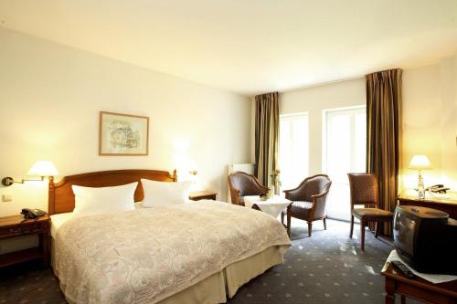 Girod弗雷穆尔餐厅酒店的酒店客房配有床、椅子和电视。