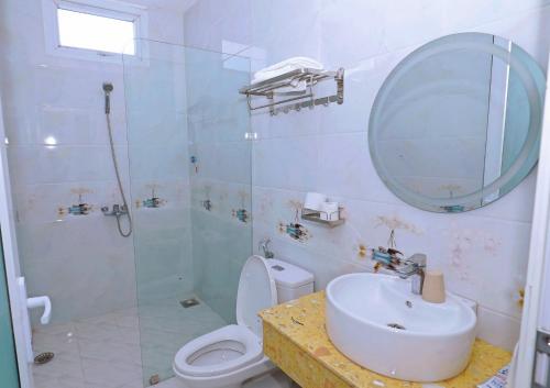 邦美蜀洪王酒店的一间带卫生间、水槽和镜子的浴室
