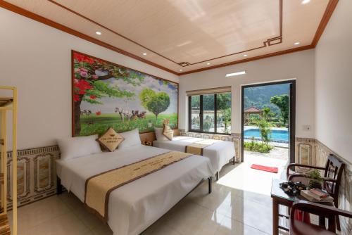 宁平Tan Dinh Farmstay的卧室内的两张床,墙上有绘画作品