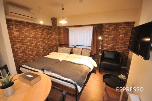 大阪Maison Milano Nakatsu Apartment的一间卧室设有一张床和砖墙