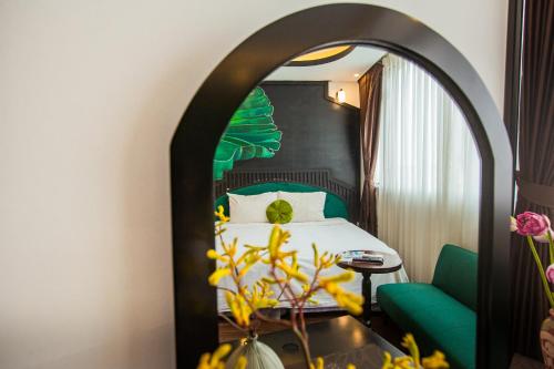 河内Hanoi Center Silk Boutique Hotel & Travel的酒店客房,配有一张床和一把绿色椅子