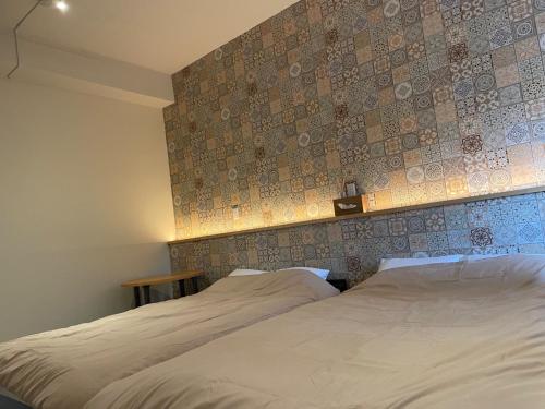 志摩市Small Resort Shima - Vacation STAY 96429v的一间带两张床的卧室和瓷砖墙