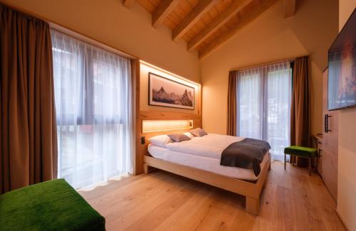采尔马特Hotel Tannenhof的一间卧室设有一张床和一个大窗户