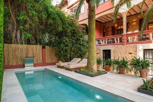马略卡岛帕尔马Hotel Can Quetglas的庭院中带房子的游泳池