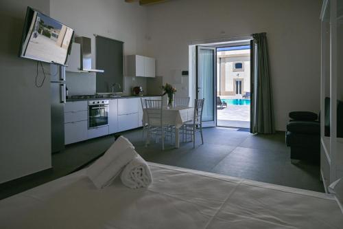 马尔扎梅米Dimora Savarino Marzamemi Suites with pool的厨房以及带桌子的客厅。