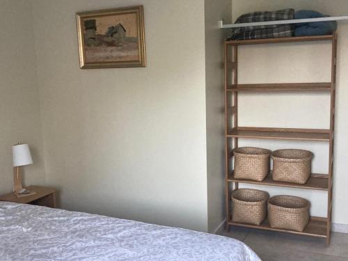 罗亚LUČI jūras apartamenti 2的一间卧室配有一张床和一个装有篮子的架子