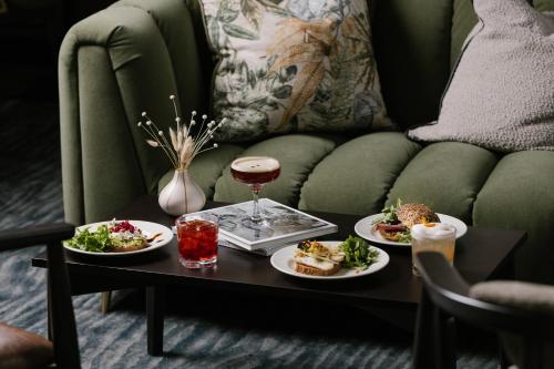 爱丁堡Native Edinburgh的一张桌子,上面放着两盘食物和一杯葡萄酒