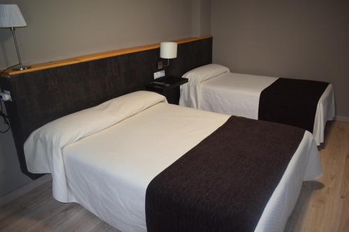 莱斯卡耐伽胡安酒店的白色和黑色的酒店客房内的两张床