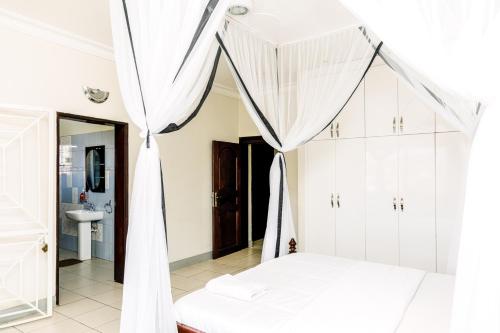 坎帕拉Luxury Acacia Villa with Kampala's Best View的一间卧室配有一张带蚊帐的床