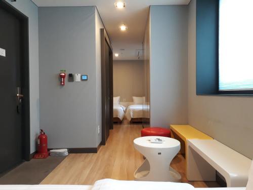 首尔格瑞德酒店的浴室设有白色卫生间和红色凳子。