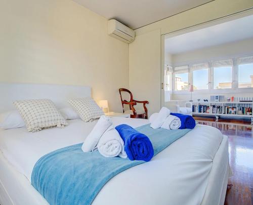 马略卡岛帕尔马VILLA BONANOVA STYLE的白色的床,上面有蓝色的白色毛巾