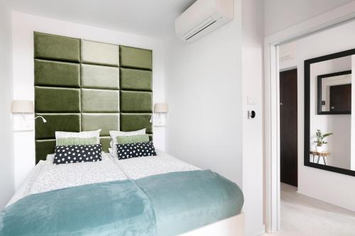 克拉科夫Partnerapart Rakowicka 14 Kamienica的一间卧室配有一张大床和绿色床头板