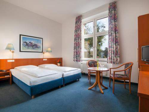 杜塞尔多夫Trip Inn Hotel Schumann的酒店客房设有两张床和一张桌子。
