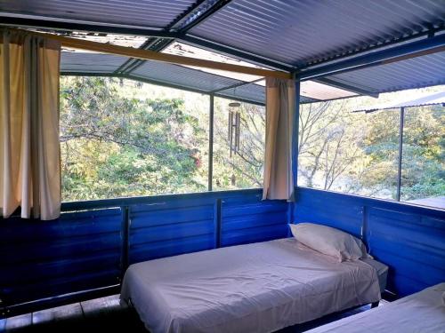 兰金Room in Cabin - Rafting Hut by The River的带2扇窗户的客房内的2张床