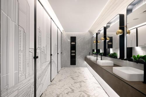 迪拜Ecos Dubai Hotel at Al Furjan的浴室设有2个水槽和2面镜子