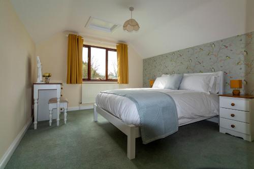布兰斯福德Bransford Farm Fishery & B & B的卧室配有白色的床和窗户。