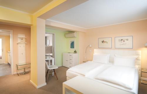帕德博恩Arthotel ANA Fleur的卧室配有白色的床和椅子