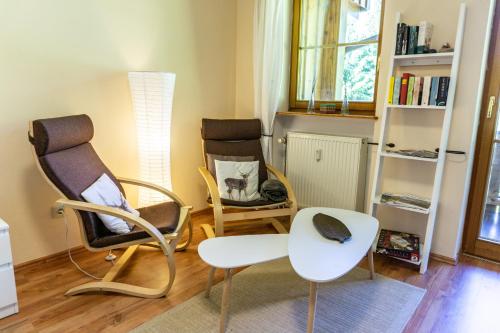 林德伯格Apartment zum Wohlfühlen mitten im Grünen的客厅配有两把椅子和一张桌子