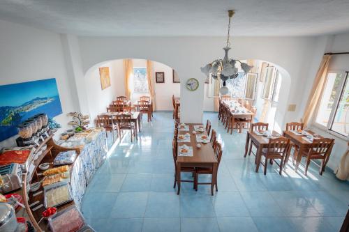 伊斯基亚Hotel Casa Adolfo Ischia的一间在房间内配有桌椅的餐厅