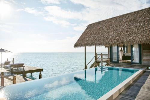 马累COMO Cocoa Island - Partner Travels FREE for 7 Nights or More的一座位于大海上的房子前的游泳池