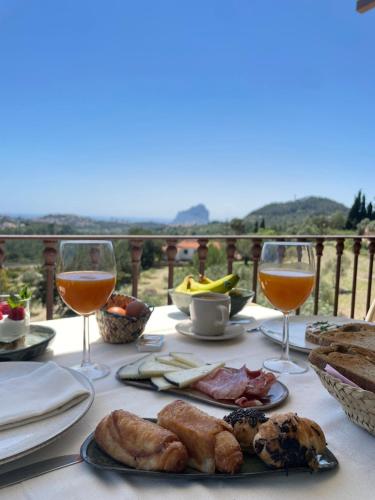 贝尼萨Villa Riu Blanc的一张桌子,上面有食物和两杯葡萄酒