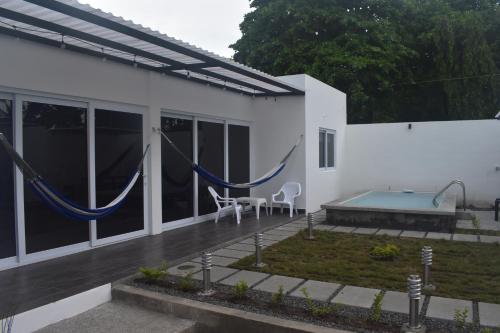 Playa San BlasEl Salvador Surf Houses的白色的房子外面设有吊床
