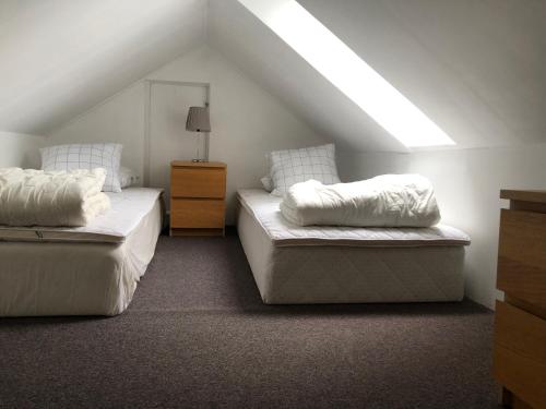 斯卡拉Lillstugan的阁楼卧室设有两张床和窗户。