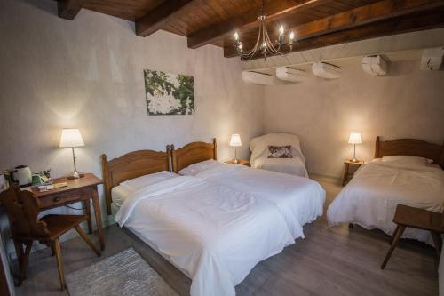 奥特罗特Chambres d'Hôtes Chez Mado Ottrott的一间卧室配有两张床、一张桌子和两盏灯。