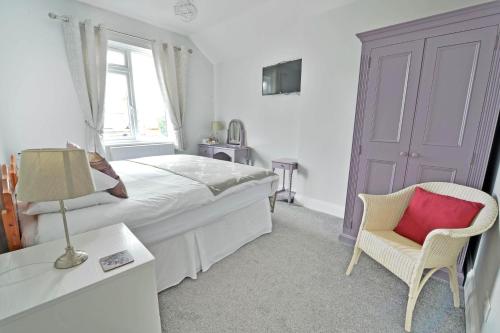 埃文河畔斯特拉特福Broadlands Guest House的卧室配有床、椅子和窗户。