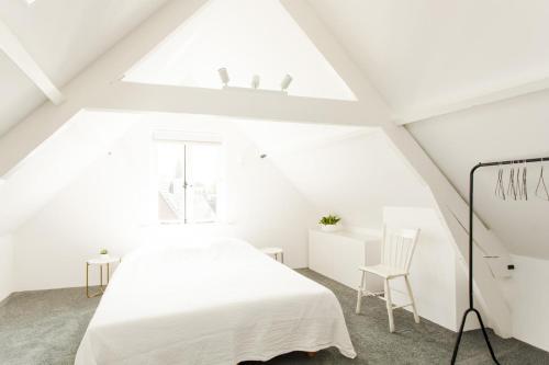 多德雷赫特Amazing and stylish house near city center Dordrecht, close to Rotterdam的白色的阁楼卧室设有床和窗户