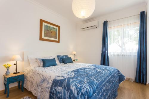圣卢西亚岛Dream holidays @ Santa Luzia Tavira的卧室配有蓝色和白色的床和窗户。