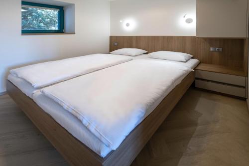 雷德尼斯Apartmány Na Zahradách的卧室内的一张带白色床单的大床
