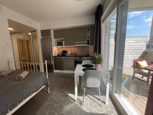 图尔库The Seabreeze Apartment Turku的一间卧室配有一张床铺和一张桌子,还设有一间厨房