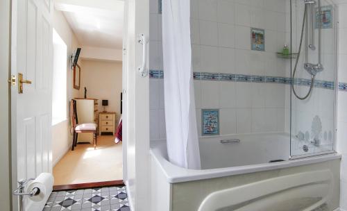 霍尔斯沃西Leworthy Farmhouse Bed and Breakfast的带淋浴和浴缸的浴室