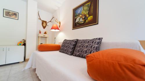 弗济内Karolina的卧室配有白色床和橙色枕头