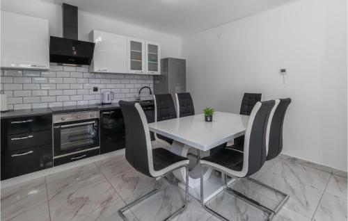 奥托查茨Cozy Apartment In Otocac With Wifi的厨房配有白色的桌椅