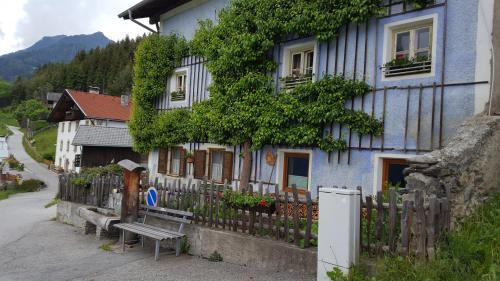 施图拜谷地特尔费斯Ferienwohnung Jörgenhof的蓝色的房子,设有木栅栏和长凳