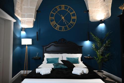 布林迪西Poesìa的一间设有蓝墙大钟的卧室