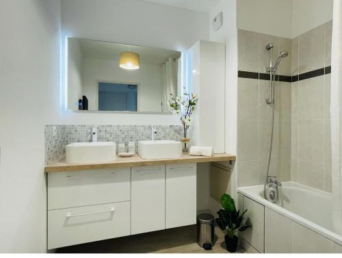 尚特洛普恩布里Joli appartement Proche Disney的浴室设有2个水槽、镜子和浴缸。