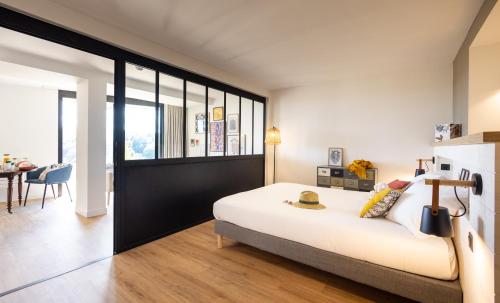 拉加西利La Bergerie Yves Rocher的卧室配有一张白色的大床和一张桌子
