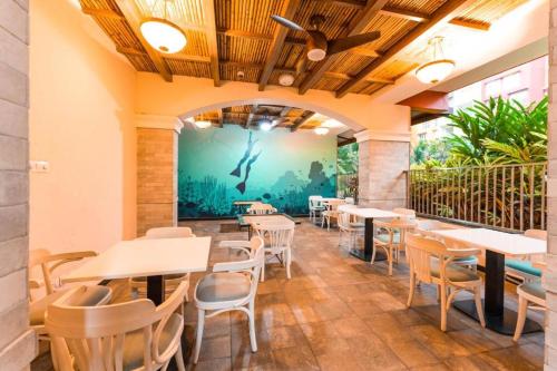 ChicalimTATA Rio De Goa - Resort style apt,6 KM from Airport的一间带桌椅和壁画的餐厅