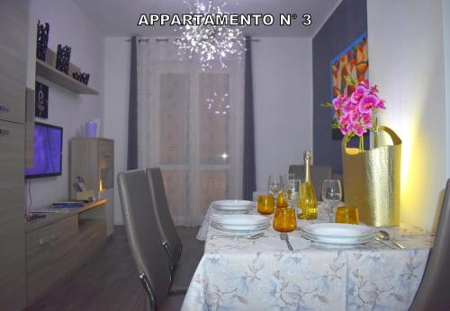 代森扎诺-德尔加达Red & Blu Apartments的餐桌上摆放着盘子和鲜花