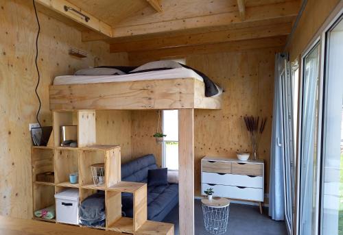 StreefkerkTiny house het Polderhuisje的木屋内设有一间带双层床的卧室