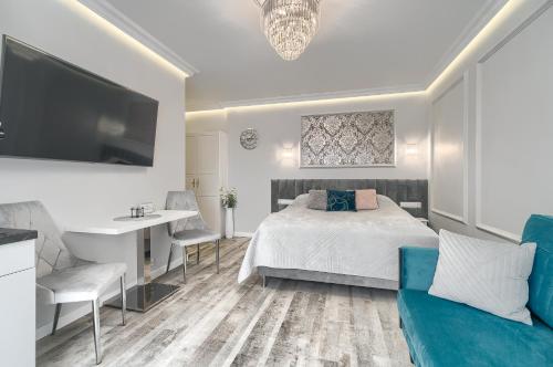 斯维诺乌伊希切Silver Apartments的一间卧室配有一张床、一张书桌和一台电视。